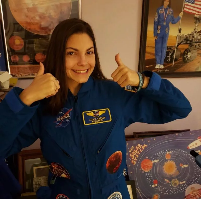 Alyssa Carson wearing an astronaut suit with a determined look.